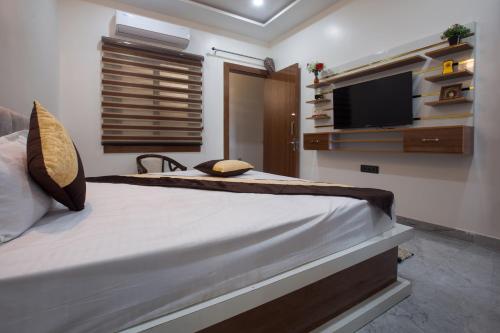 a bedroom with a large bed and a flat screen tv at Madhav Residency in Mathura