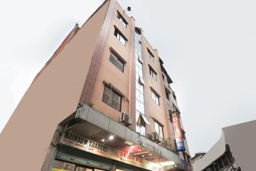 un edificio alto marrón con un letrero. en SPOT ON 81399 Hotel Rainbow Regency en Rourkela