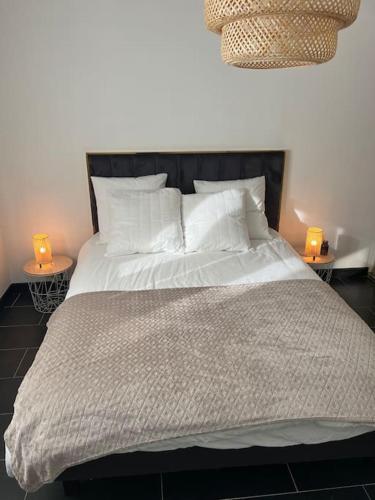 - un lit avec deux bougies sur deux tables dans une chambre dans l'établissement Magnifique appartement lumineux, à Marseille