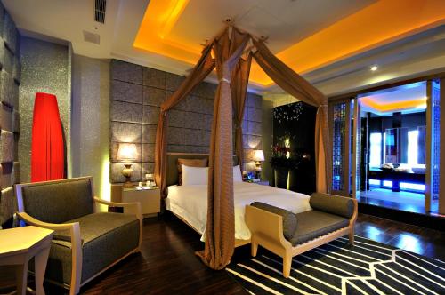 1 Schlafzimmer mit einem Himmelbett und 2 Stühlen in der Unterkunft Dubai Motel in Yilan