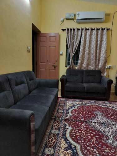 - un salon avec un canapé et un tapis dans l'établissement PRATIKSHA - HOME FOR HOLIDAYS, à Kundapur