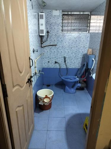 uma casa de banho azul com um WC e uma banheira em PRATIKSHA - HOME FOR HOLIDAYS em Kundapur