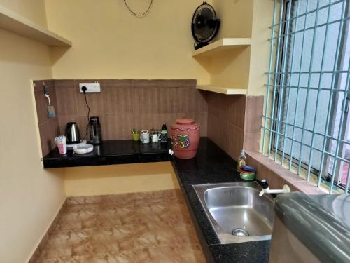 uma cozinha com um lavatório e uma bancada em PRATIKSHA - HOME FOR HOLIDAYS em Kundapur