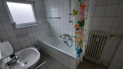 a bathroom with a sink and a tub and a window at Black Stone Apartments - Lörrach in Lörrach