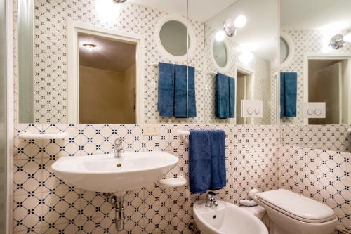 ein Bad mit einem Waschbecken, einem WC und einem Spiegel in der Unterkunft Lake Charming Apartment in Cernobbio