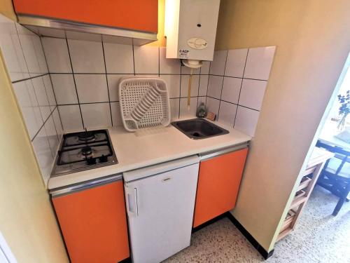 une petite cuisine avec un évier et une cuisinière dans l'établissement 085 Cap city C27, au Cap d'Agde