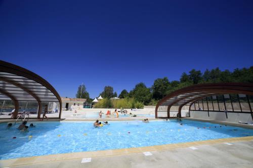 una gran piscina con gente en el agua en Terres de France - Les Hameaux des Lacs en Monclar-de-Quercy