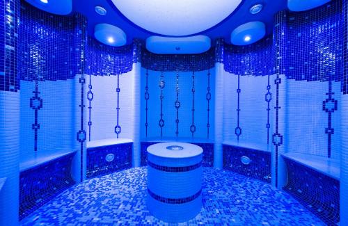 a bathroom with blue tiled walls and a toilet at Hotel Bystrina in Demanovska Dolina