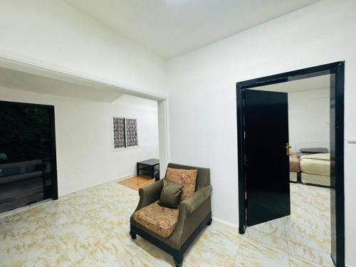 a living room with a chair and a mirror at Private Entrance 2 Bedroom Apartment fully furnished in Abu Dhabi