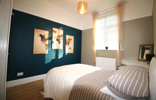 Large 3 Bed Bungalow - Beautiful Refurb - Garden في برمنغهام: غرفة نوم بها سرير ولوحات على الحائط