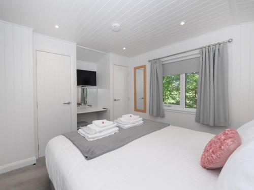 Un dormitorio blanco con una cama con toallas. en 1 bed in Langbank 73845, en Langbank