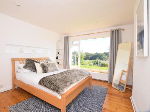 sypialnia z łóżkiem i dużym oknem w obiekcie 4 Bed in Brixham 76402 w mieście Brixham