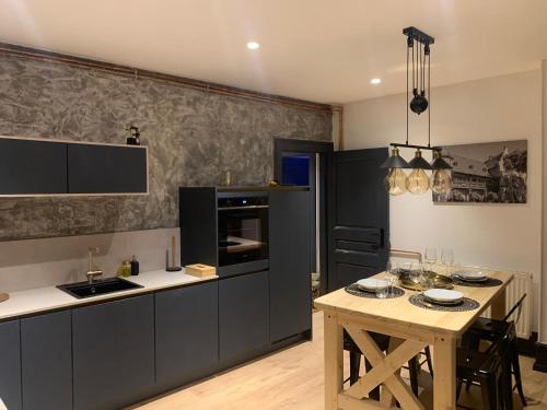 a kitchen with black cabinets and a wooden table at Édouard & Richard in Colmar