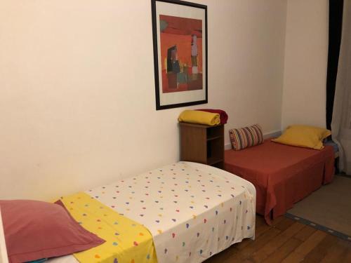 une chambre avec deux lits et un tableau au mur dans l'établissement 47m2 Calme au cœur de Parîs, à Paris