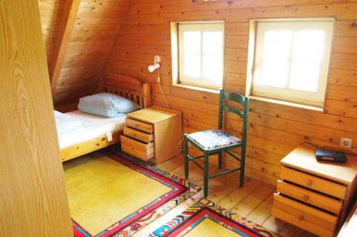 1 dormitorio con 1 cama y 1 silla en una cabaña en Ferienhof Wikner, en Bruchhausen-Vilsen