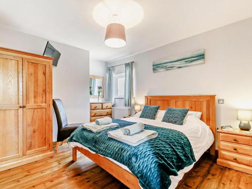 a bedroom with a large bed and a chair at 1 Bed in Sennen GIDUP in St Just