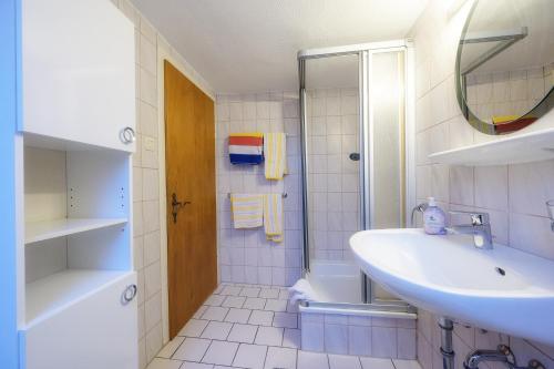 bagno bianco con lavandino e doccia di Appartment am Kurpark a Lippstadt