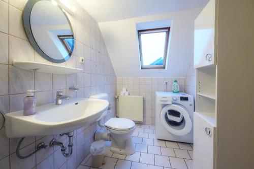 bagno con lavabo, servizi igienici e lavatrice. di Appartment am Kurpark a Lippstadt
