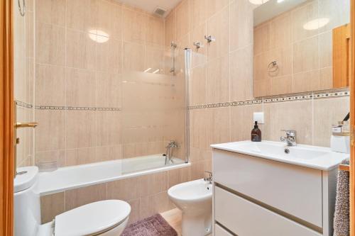 een badkamer met een toilet, een wastafel en een bad bij Casa Sócrates in Nerja