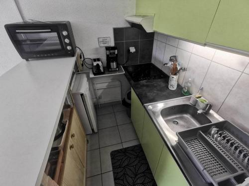 une petite cuisine avec un évier et une cuisinière dans l'établissement 026 Beverley Hills C42, au Cap d'Agde