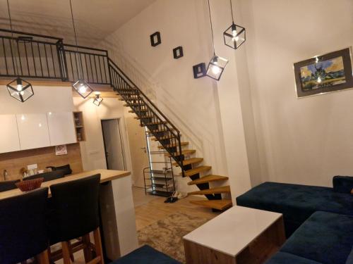 sala de estar con escalera y sofá azul en Apartman BJELA, en Bjelašnica
