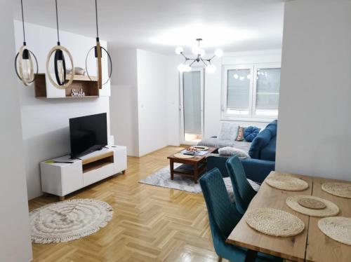 ein Wohnzimmer mit einem blauen Sofa und einem Tisch in der Unterkunft Apartman Ristic in Požarevac