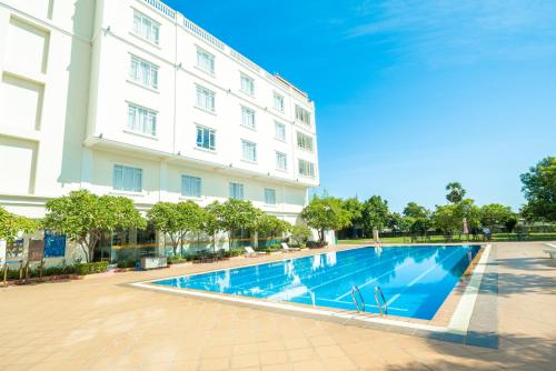 a swimming pool in front of a building at Pursat Riverside Hotel & Spa in Pursat