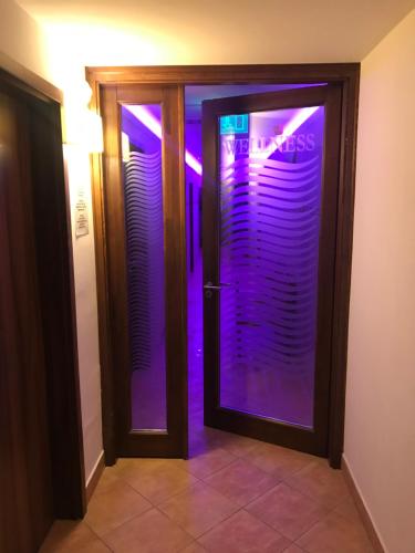 Una puerta de cristal con luces moradas. en Meggyes Hotel, en Szerencs