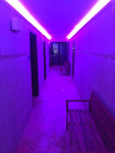 Un pasillo púrpura con un banco en una habitación en Meggyes Hotel, en Szerencs