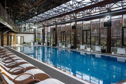 a large swimming pool with chairs in a building at Jannat Regency in Bishkek