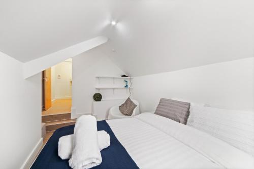 Un dormitorio con una cama blanca con toallas. en Wonderful Stay 2 Bedrooms Flat, en Leicester