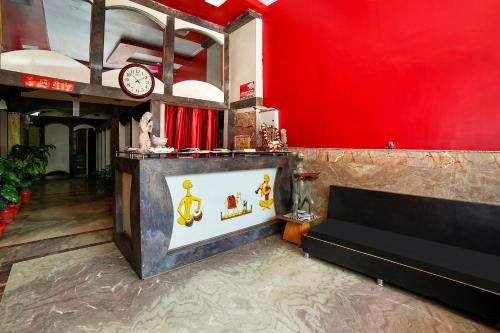 salon z kanapą i czerwoną ścianą w obiekcie OYO Rama Utsav w mieście Gwalijar
