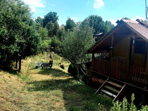 a cabin in a field with a bench and trees at Krushka, Kochani, Osogovo in Kočani