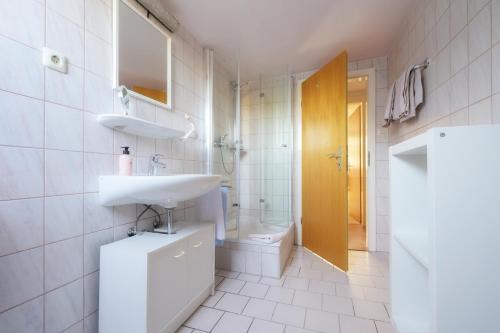 a white bathroom with a sink and a toilet at Wohnung am Kurpark in Lippstadt