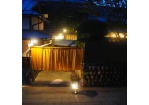a cat sitting on a sidewalk at night with lights at fumoku - Vacation STAY 04226v in Chino