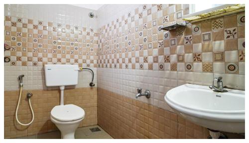 La salle de bains est pourvue de toilettes et d'un lavabo. dans l'établissement Kay Kay Residency, à Cochin