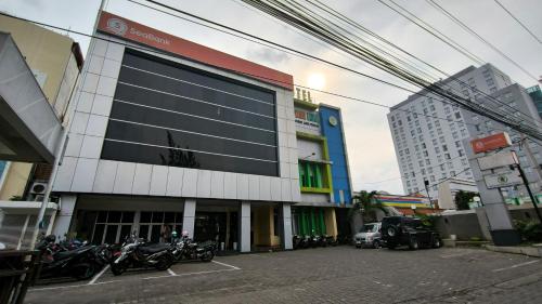 een gebouw met motorfietsen geparkeerd op een parkeerplaats bij Hotel Simpang Lima Semarang in Semarang