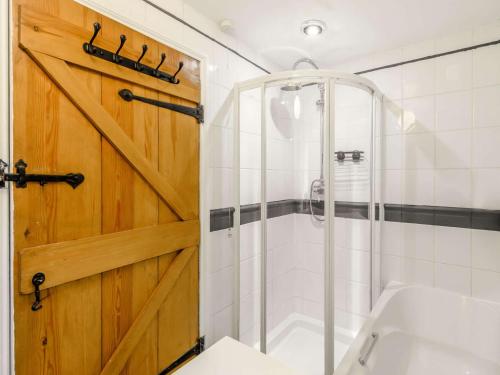 a bathroom with a shower and a wooden door at 4 Bed in Hawes 89363 in Hawes