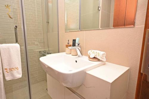 阿布達比的住宿－Al Reem Paragon 1BR Apartment，浴室配有白色水槽和淋浴。