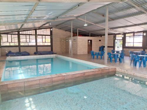 a large swimming pool with blue chairs and tables at Pousada Juriti - Eco Hotel in São Roque