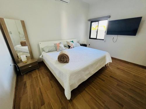 a bedroom with a large white bed and a mirror at La Ventana Apartments #6 in La Ventana