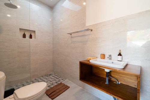 uma casa de banho com um lavatório e um WC em Casa de Cavendish em Dalung