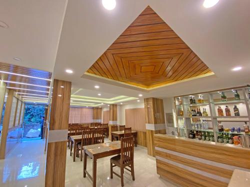 un restaurante con techos de madera, mesas y sillas de madera en Hotel Dipjyoti en Katmandú