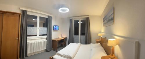 Habitación de hotel con cama y ventana en Hotel Rheinfall en Neuhausen am Rheinfall