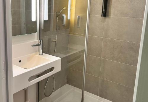 a bathroom with a shower and a sink at B&B HOTEL Massieux Genay in Genay