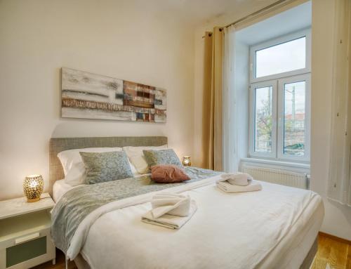 een slaapkamer met een groot bed en 2 handdoeken bij Flarent Vienna Apartments-WG in Wenen