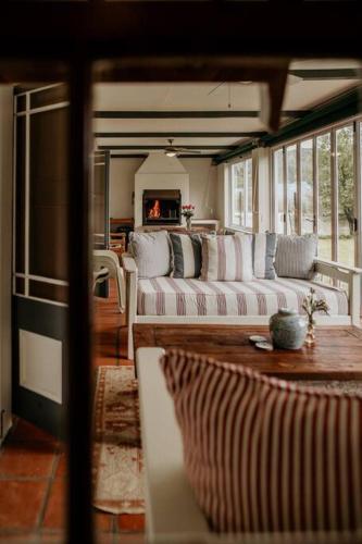 a living room with white couches and a fireplace at Die Stal at Antioch in Franschhoek