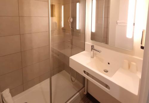 La salle de bains est pourvue d'une douche et d'un lavabo. dans l'établissement B&B HOTEL Nice Stade Riviera, à Nice