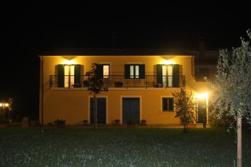 a large yellow house with a balcony at night at Il Podere di Francesco in Rivotorto 