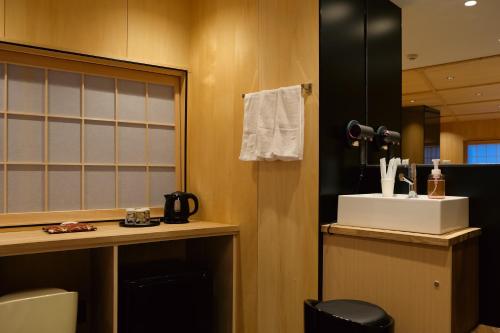 a bathroom with a sink and a desk and a mirror at 万雷ホテル in Tokyo